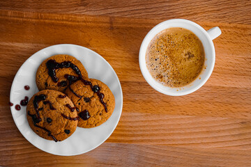 Oatmeal cookies and a cup of coffee on a table with a wooden texture