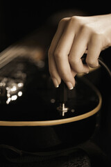 Plugging cable into electric guitar