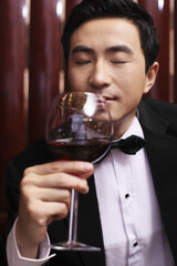 Man in tuxedo enjoying wine