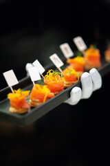 mini canape with smoke salmon on waiter hand ready to serve