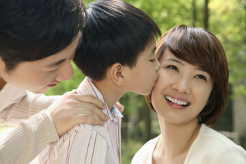 Fototapeta premium Boy kissing woman, man smiling while watching