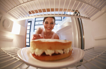 Woman taking cake from the refrigerator