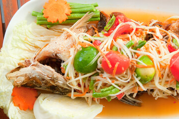Thai food - som tum spicy papaya salad combination with deep fried fish