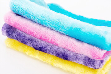Different coloured rags stacked together on a white background