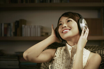 Woman smiling while listening to music on the headphones