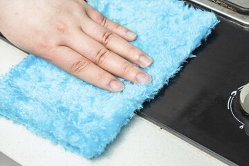 One hand is holding a cleaning cloth and cleaning it with alcohol-based disinfectant.