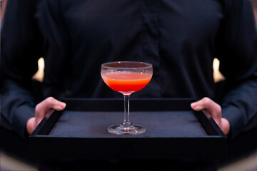 waiter serving red cocktail