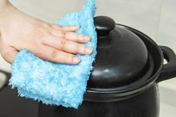 Disinfection of kitchen utensils with an alcohol-based disinfectant wipe and a cloth in one hand.