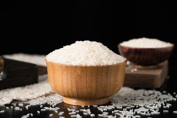 A wooden bowl holds dried Thai fragrant rice in a vintage setting