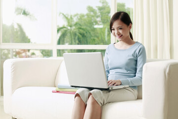 Woman sitting on the couch using laptop