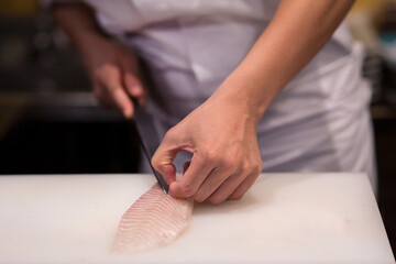 Fototapeta na wymiar Japanese chef is neatly cutting on fish