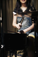 Obraz na płótnie Canvas Young woman playing drums