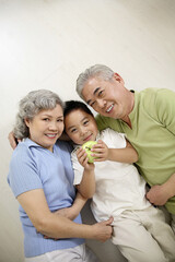 Boy posing on the floor with senior man and senior woman