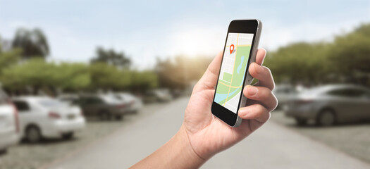 Hand holding smartphone device and touching screen, which is a red icon of the location, Concept of online navigation