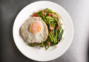 fried water spinach with sliced pork and sunny egg on rive