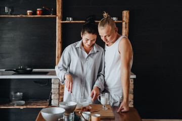 Beautiful young couple preparing a healthy meal together while spending free time at home .