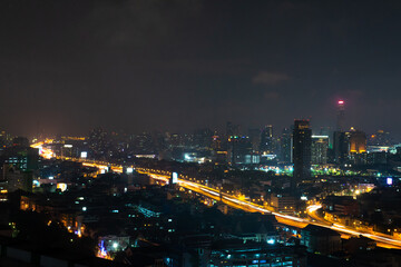 Fototapeta na wymiar Yellow line from expressway corss the urban city along skyscraper in the night