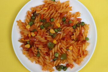 Red fusillli pasta with vegetables, corn, peas, red sauce