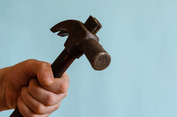 Close-up of a male hand striking with a hammer.