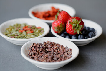 Various legumes and different kinds of nuts in spoons. Walnuts kernels ,hazelnuts, almond ,brown pinto ,soy beans ,flax seeds ,chia ,red kidney beans and pecan set up on white gray background