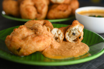 Medu Vada with tiffin sambar coconut chutney in banana leaf plate ,savoury fried snack of Kerala, Tamil Nadu South India. Top view of Indian veg breakfast food.