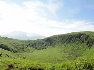 Fototapeta premium An old crater of Mt.Kijima and small eruption of Mt.Aso(active volcano) in Kumamoto Japan