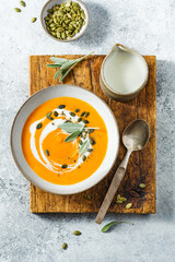 Creamy pumpkin soup with pumpkin seed and fresh herbs. Top view.