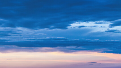 Obraz premium Blue evening sky with picturesque clouds. The last rays of the setting sun.