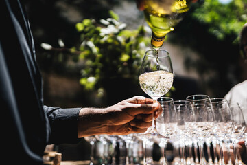 Camarero sirviendo una copa de vino blanco