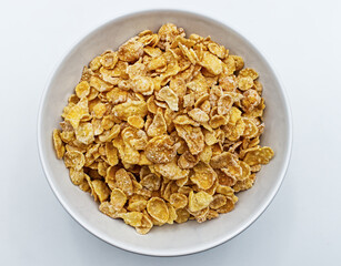 Cornflakes in a bowl isolated on white. Top view 