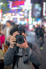 young photographer taking picture in urban city