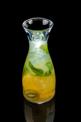 cold drink with pineapple, kiwi, mint and ice on a black background