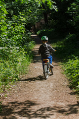 Fototapeta na wymiar boy in a helmet on a bicycle in the park