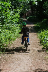Fototapeta na wymiar boy in a helmet on a bicycle in the park