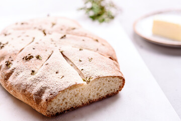 Homemade fresh baked Fougasse (French Bread) with thyme and olive oil on white background. Traditional Provencal dishes. Selective focus