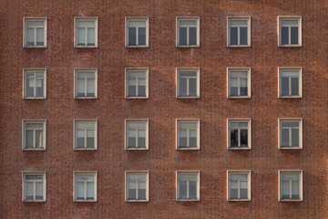 Many windows in a row on the wall of urban apartment building