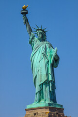Close shot of Statue of Liberty in New York City, with blue sky.