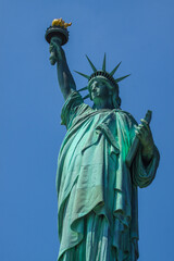 Close shot of Statue of Liberty in New York City, with blue sky.
