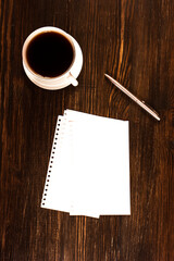cup of coffee and notebook o wooden desk
