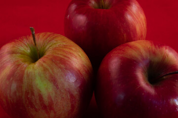 close up of many delicious shiny apple on a red studio background