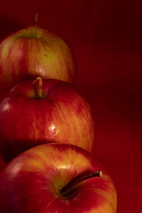 close up of many delicious shiny apple on a red studio background