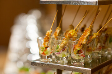 Chicken satay in th glasses set for canapes for the break