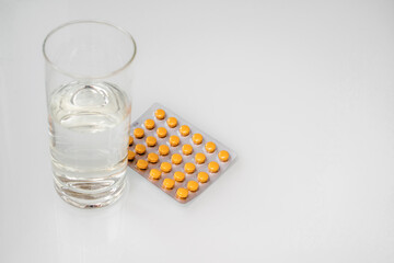 A package of orange tablets is placed on a white background