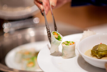 People tonging  wrap  stuff on plate