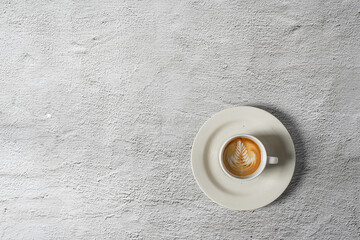 A top view of a delicious coffee in a cup near the roasted beans spread on a white background.Top view with copyspace for your text.