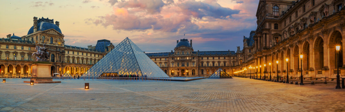 View of famous Louvre Museum with Louvre Pyramid at evening
