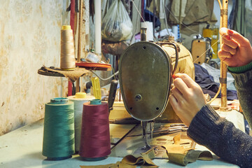 Woman tailor using retro sewing machine at home, hobby concept.