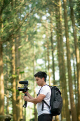 young man is  recording vedio in the nature