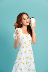 Fashion portrait pretty cool girl drinks a juice from cup holds slice watermelon