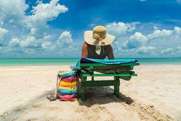 Woman on a sun lounger at the white sand tropical beach